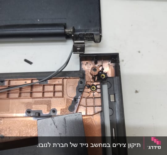 חלקי מחשב נייד פתוחים עם צירים וחוטים גלויים